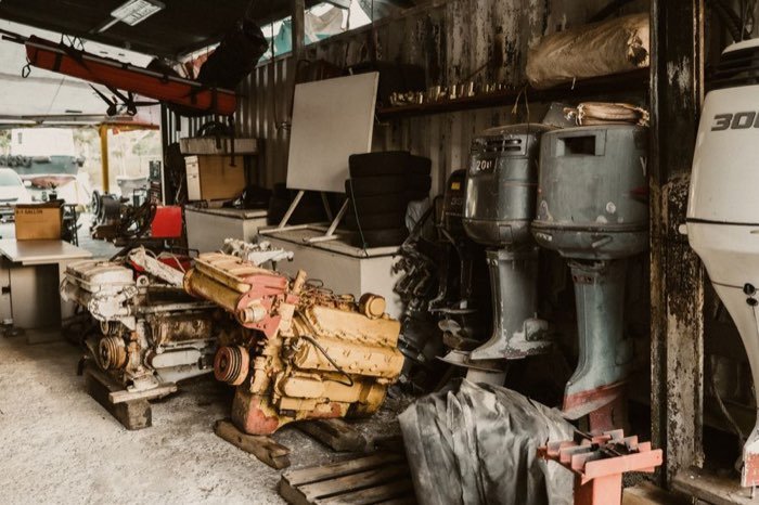 Marine engines and outboard units in a workshop awaiting overhaul.